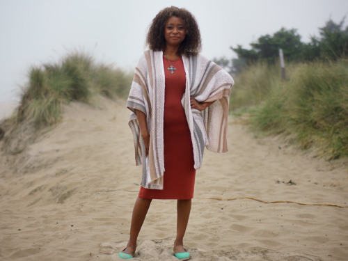 Eva standing on the beach in fashionable attire